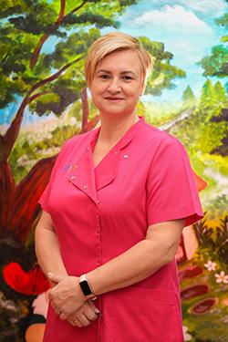 Pracownica żłobka w stroju służbowym, ujęcie portretowe.